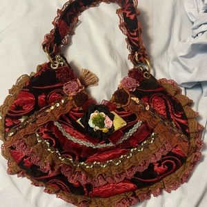 Red purse, with a bunch of flowers, sequins, and lace